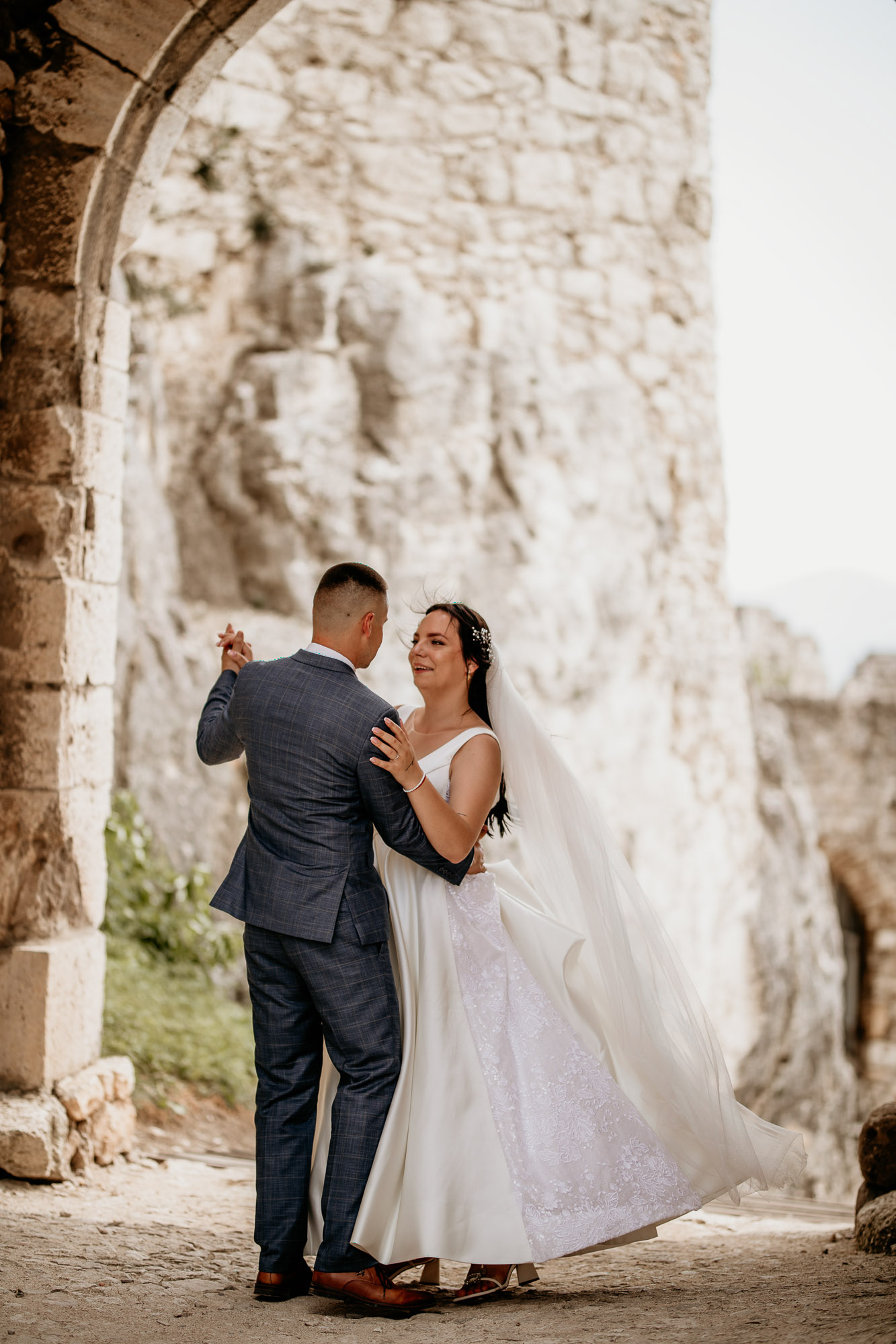Dominika a Marián pri výstupe po schodoch Spišského hradu, ruka v ruke, obklopení krásnym letným slnkom.